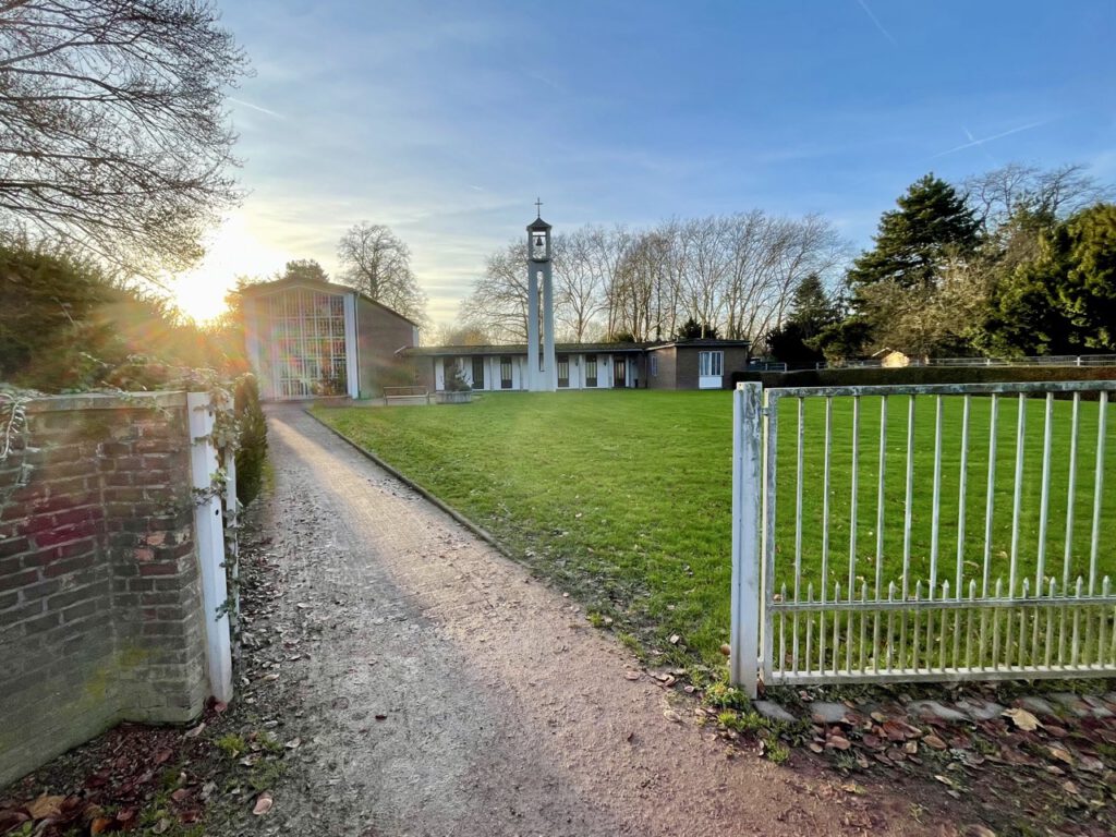 Eingangsbereich des Friedhofs in Willich mit Grünflächen und denkmalgeschützter Trauerhalle